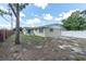 Spacious backyard with brick and white fence provides a quiet retreat at 2954 Leisure Ct, Dunedin, FL 34698