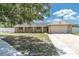 Charming single-story home with a brick facade, well-maintained lawn, and attached two-car garage at 2954 Leisure Ct, Dunedin, FL 34698