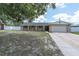 Charming single-Gathering home with a well-maintained front yard and a two car garage at 2954 Leisure Ct, Dunedin, FL 34698