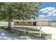 Charming single-story home with a well-manicured lawn and a large shade tree in the front yard at 2954 Leisure Ct, Dunedin, FL 34698