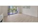 Bright living room with sliding glass doors leading to screened lanai and view of pond at 3134 Lake Pine Way # F2, Tarpon Springs, FL 34688