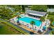 Community pool and spa area with lounge chairs, palm trees, and a clubhouse surrounded by lush landscaping at 3134 Lake Pine Way # F2, Tarpon Springs, FL 34688