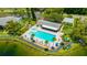 Community pool and spa area with lounge chairs, palm trees, and a clubhouse surrounded by lush landscaping at 3134 Lake Pine Way # F2, Tarpon Springs, FL 34688