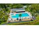 Community pool with lounge chairs and palm trees surrounding the area, alongside a grill and a covered seating at 3134 Lake Pine Way # F2, Tarpon Springs, FL 34688