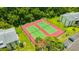 Aerial view of two tennis courts and parking surrounded by lush greenery in a well-maintained community at 3134 Lake Pine Way # F2, Tarpon Springs, FL 34688