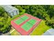 Aerial view of two tennis courts surrounded by lush greenery in a well-maintained community at 3134 Lake Pine Way # F2, Tarpon Springs, FL 34688