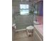 Modern bathroom with a glass-enclosed shower, white fixtures, and gray marble tile at 3336 Gulfview Dr, Hernando Beach, FL 34607