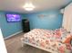 Bright bedroom with blue walls, a white bed frame, and cheerful coral-themed bedding, with a wall-mounted television at 3336 Gulfview Dr, Hernando Beach, FL 34607