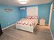 Bright bedroom with blue walls, a white bed frame, and cheerful coral-themed bedding at 3336 Gulfview Dr, Hernando Beach, FL 34607