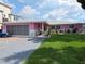 Charming pink home with a well-maintained lawn and brick-paved driveway, creating a welcoming curb appeal at 3336 Gulfview Dr, Hernando Beach, FL 34607