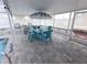 Covered patio area featuring a blue dining set, outdoor grill, and waterfront view at 3336 Gulfview Dr, Hernando Beach, FL 34607