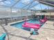 Screened-in pool area with pink flamingo floaties and waterfront views at 3336 Gulfview Dr, Hernando Beach, FL 34607