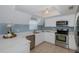Bright kitchen with stainless steel appliances, white cabinets, and blue backsplash at 3363 Poinsettia Dr, Hernando Beach, FL 34607