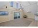 Bright living room boasts high ceilings, fan, and sliding glass doors to patio at 3363 Poinsettia Dr, Hernando Beach, FL 34607