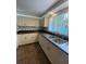 Bright kitchen features white cabinets, dark countertops, stainless sink, and window providing ample natural light at 3530 Beechwood N Ter, Pinellas Park, FL 33781