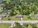 Aerial view showcasing the home's large lot surrounded by mature trees in a neighborhood at 37722 Granada Ave, Dade City, FL 33525