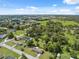 Aerial view of a community with trees, homes, and open fields on a partly cloudy day at 37722 Granada Ave, Dade City, FL 33525