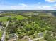 Aerial view of a neighborhood with trees, roads, and a distant lake visible at 37722 Granada Ave, Dade City, FL 33525