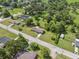 Aerial view of neighborhood homes surrounded by mature trees with a long road at 37722 Granada Ave, Dade City, FL 33525