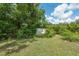 Spacious backyard features a well-maintained lawn, mature trees, and a shed for extra storage space at 37722 Granada Ave, Dade City, FL 33525