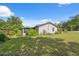 Landscaped backyard with mature trees and green grass surrounding the home at 37722 Granada Ave, Dade City, FL 33525