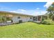 Expansive backyard featuring green grass, a covered patio, and a screened-in porch at 37722 Granada Ave, Dade City, FL 33525