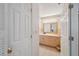 Well-lit bathroom with beige cabinetry, a large mirror, and neutral countertops at 37722 Granada Ave, Dade City, FL 33525