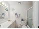 Bright bathroom features a white vanity, mirror with decorative lighting, and a walk-in shower with glass door at 37722 Granada Ave, Dade City, FL 33525