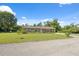 Single-story home with a well-kept lawn and mature trees, situated on a spacious lot at 37722 Granada Ave, Dade City, FL 33525