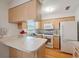 Bright kitchen features white appliances, light wood cabinets, and an open counter space at 37722 Granada Ave, Dade City, FL 33525