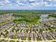 Aerial view of home showcasing the neighborhood, nearby lake, and mature trees at 3897 Villamore Ln, Odessa, FL 33556