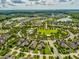 Serene aerial view of a residential community with winding roads, lush landscaping, and a swimming pool at 3897 Villamore Ln, Odessa, FL 33556