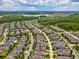 Expansive aerial view of neighborhood with houses, landscaping, and a lake in the distance, showcasing community living at 3897 Villamore Ln, Odessa, FL 33556