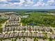 Aerial view of home showcasing the neighborhood, nearby lake, and mature trees at 3897 Villamore Ln, Odessa, FL 33556