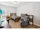 Neutral bedroom with a gray recliner, wood look floors, and modern furniture at 3897 Villamore Ln, Odessa, FL 33556