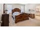 Inviting bedroom featuring a decorative headboard, natural light, neutral paint and carpet, and desk area at 3897 Villamore Ln, Odessa, FL 33556