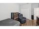Cozy bedroom featuring wood look floors, a gray recliner, and a dresser at 3897 Villamore Ln, Odessa, FL 33556