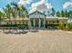 Community center exterior showcasing brick accents, tall pine trees, and ample parking space at 3897 Villamore Ln, Odessa, FL 33556