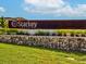 Starkey Ranch community entrance sign with stone wall and greenery under a partly cloudy sky at 3897 Villamore Ln, Odessa, FL 33556