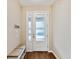 Welcoming entryway features a white front door, light tile floors, seating area, and wall-mounted hooks at 3897 Villamore Ln, Odessa, FL 33556