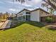 Modern home with floor-to-ceiling glass windows and doors overlooking a lush green lawn at 3897 Villamore Ln, Odessa, FL 33556