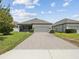 Charming single-story home with a well-maintained lawn and a two-car garage at 3897 Villamore Ln, Odessa, FL 33556