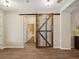Hallway featuring a decorative barn door and wood look floors at 3897 Villamore Ln, Odessa, FL 33556