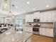 Open kitchen boasts granite countertops, stainless steel appliances and stylish pendant lights at 3897 Villamore Ln, Odessa, FL 33556