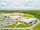 Aerial view of school building with multiple buildings, play area and surrounding green space offering excellent learning environment at 3897 Villamore Ln, Odessa, FL 33556