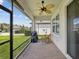 Cozy screened-in porch with ceiling fan, outdoor furniture, and view of the backyard at 3897 Villamore Ln, Odessa, FL 33556