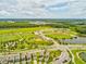 Aerial view of sports fields and a pond amidst green spaces, and nearby houses providing a picturesque location at 3897 Villamore Ln, Odessa, FL 33556