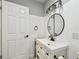 Bathroom showcasing a bright vanity, dark fixtures, and a modern round mirror at 4007 S Renellie Dr, Tampa, FL 33611