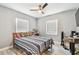 Cozy bedroom with ceiling fan, light gray walls, and natural light from two windows at 4007 S Renellie Dr, Tampa, FL 33611