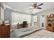 Bedroom with wood floors, ceiling fan, dresser, and a door leading to bathroom at 4007 S Renellie Dr, Tampa, FL 33611